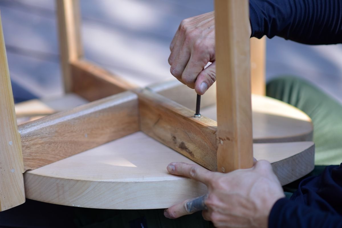 Hands assembling wooden household furniture