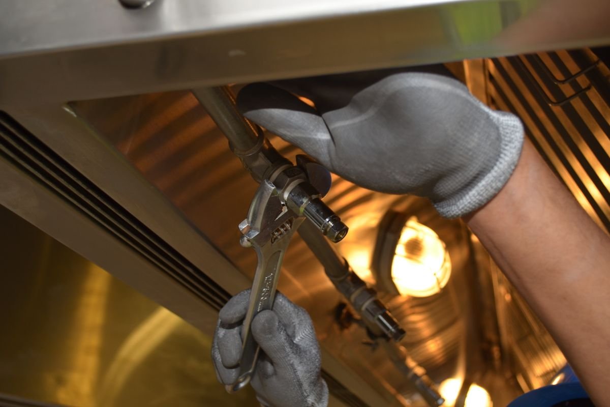 Plumber repairing pipework with a wrench